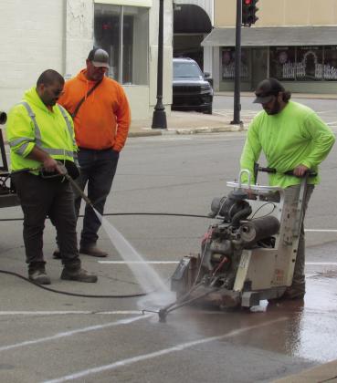 City workers Sean McDowell, Billy Hickman, and Ricky Johnson cut through the asphalt of Harrison Avenue just passed Broadway Street on April 24 in preparation for a new waterline installation. Photo by DeAnna Maddox
