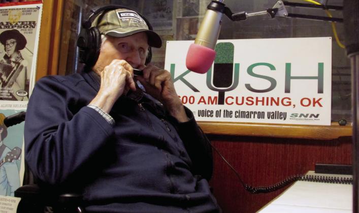 Don Wilbur plays the harmonica in the studio of KUSH Radio. Photo by DeAnna Maddox