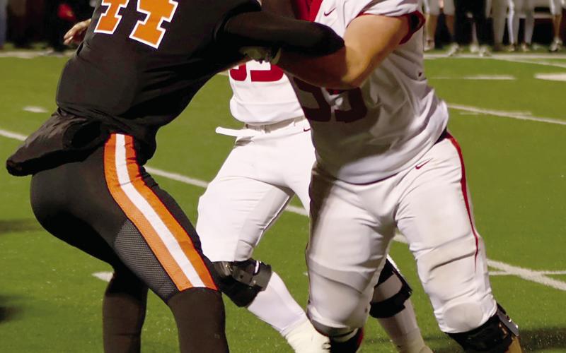 Hunter Joiner stands off with two Elgin defenders during Friday’s semi-final game at Putnam City. Photo by Sylvia Danyele