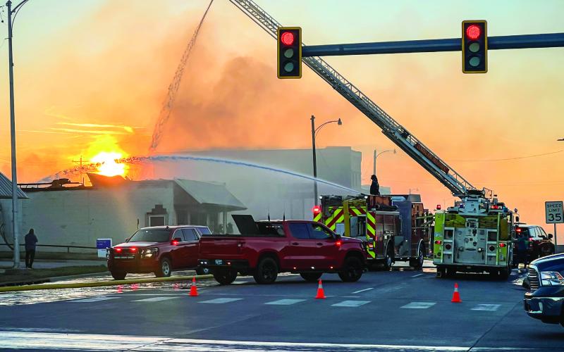 A Cushing firefighter sprays water from the top of the ladder of Truck-1, while another directs a stream of water from Engine 2 during the later phases of the firefight at the abandoned laundromat at 409 E. Main. The structure was destroyed, and no injuries were reported. More fire photos inside. Photo by J. D. Meisner