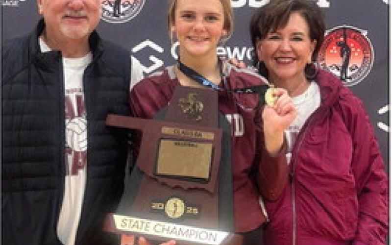 Bill and Jo Ahrberg stand with their granddaughter, Edmond Memorial Freshman Audrey-Kate Bajema, after she and her team captured the OSSAA Class 6A state volleyball title last month.