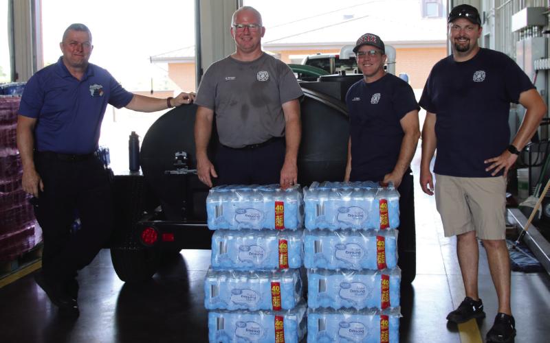 Cushing Emergency Management Director Franklin Reed, Cushing Fire Captain Justin Mincer, Cushing Fire Corporal Justin Ward, and Cushing Fire Chief Dalton Novotny stand in the fire station-turned water distribution center last week. Photo by Allie Prater