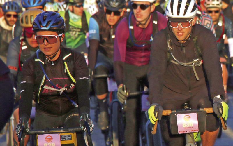 Laiken and Chris Holzer, of Perkins, make their way through the start line crowd at the start of the 100 mile Mid-South Gravel race Saturday, March 16. Photo by Allie Prater.