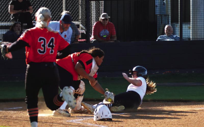 Lady Tiger courtesy runner Zoie Ledgerwood shows no fear as she slides (almost) into home Thursday. Photo by J. D. Meisner