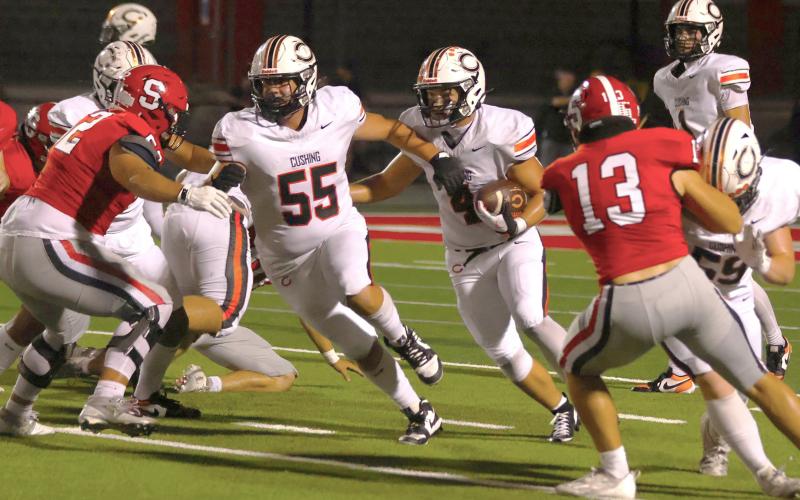 Top: Tiger QB Roman Tucker drops looks fr an opening. Above: Tiger linemen Max Hoover (55) and Logan Ford (59) clear a path past Bulldog defenders Garrett Johansen and Eli Sutton for Tiger running back Kellen Fry. Photos by Sylvia Danielle Left: The Tigers thank their fans after the game.