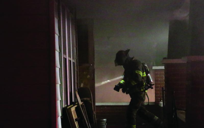 A member of the Cushing Fire Department re-enters the structure.
