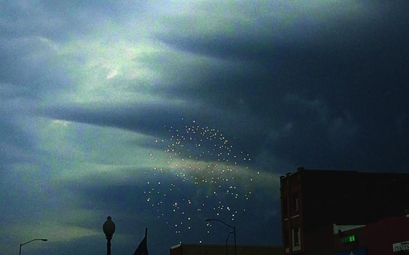A firework explodes over downtown Cushing Saturday evening as storm clouds darken the sky. The Cushing fireworks show was moved up to 7:15 p.m. on the Fourth of July due to a severe thunderstorm rolling in. Photo by Allie Prater