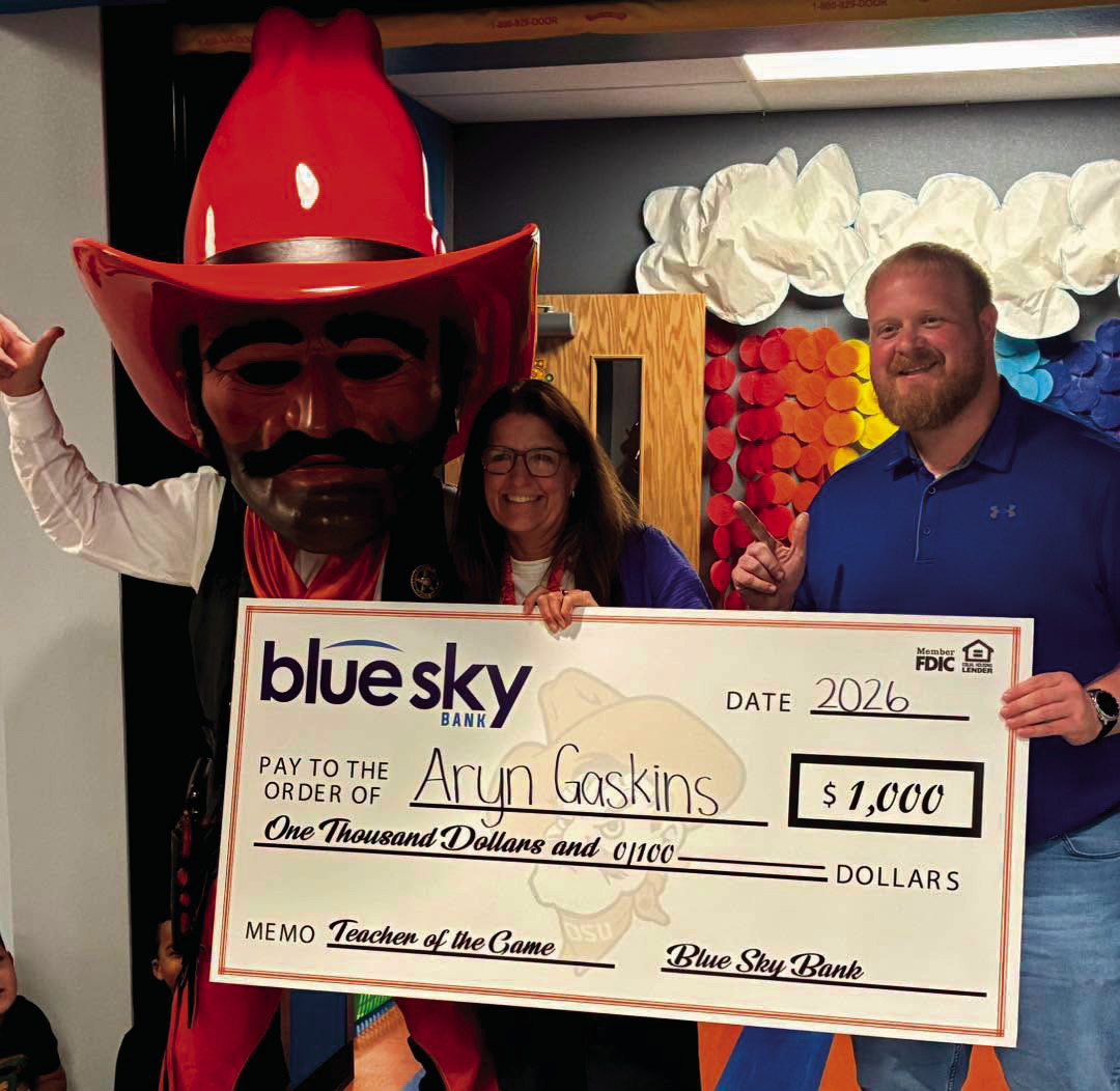 Pistol Pete and Blue Sky Bank Market President of Cushing Brian Porter Jr. present $1,000 check to Teacher of the Game recipient Aryn Gaskins.