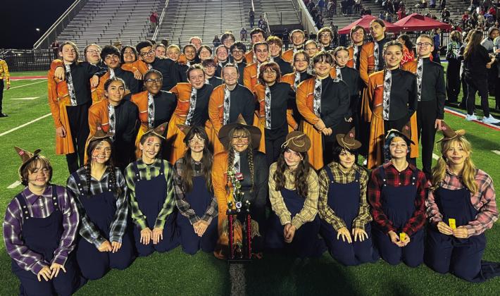The Cushing Tiger Marching Band stands with their 3rd place trophy after the preliminary round at the Bixby Tournament of Bands.