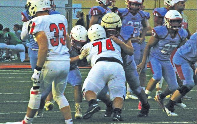 Sophomore strongman Nicolas Flores takes on two Chisolm linemen.