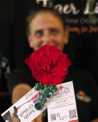 Tiger Lily’s Floral Designs owner Jenifer Hixson shows off a “Petal it Forward” carnation ahead of the Petal it Forward event Oct. 14. Photo by Allie Prater.