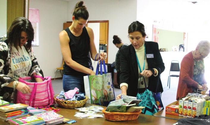 Kinetic Church TRIBE members help fi ll care totes with items purchased from donations of partnering churches. Pictured from left are Whitni Greer, Alycia Finkbeiner, Candi Bugg and Penny Cohenour.