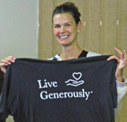 Alycia Finkbeiner holds up a shirt donated by one of the local area churches to be included in the care totes the women assembled on Nov. 12.