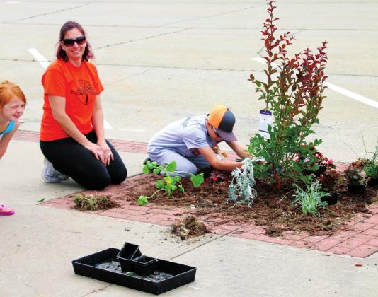 Bailey, Shawna and Caleb Swindell work to beautify their part of Broadway Saturday, during Cushing Pride’s May on Broadway event.