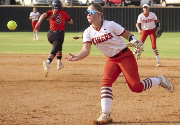 Freshman Lady Tiger Gracie Morphew throws to first to attempt to get an out on a Davenport Lady Bulldog during the Lady Tiger’s season opener Monday, Aug. 10. Photo by Allie Prater.
