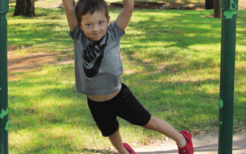 Before starting preschool at Oak Grove, Jack McDougal was at Memorial Park this Tuesday to conquer the monkey bars; a feat his granny and gramps said every young boy needed to achieve. He managed a jump and catch of the bar and even a bit of a swing. His sister had her own version — running under the bars with her hands raised. Photo by DeAnna Maddox