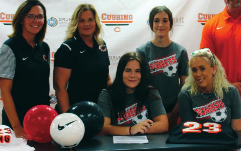 Recent Cushing graduate, Ashlynn Arnce, signs her letter of intent to play soccer at North Arkansas College on Monday at Cushing high school surrounded by family and her former coaches. Photo by Kaleb Tadpole