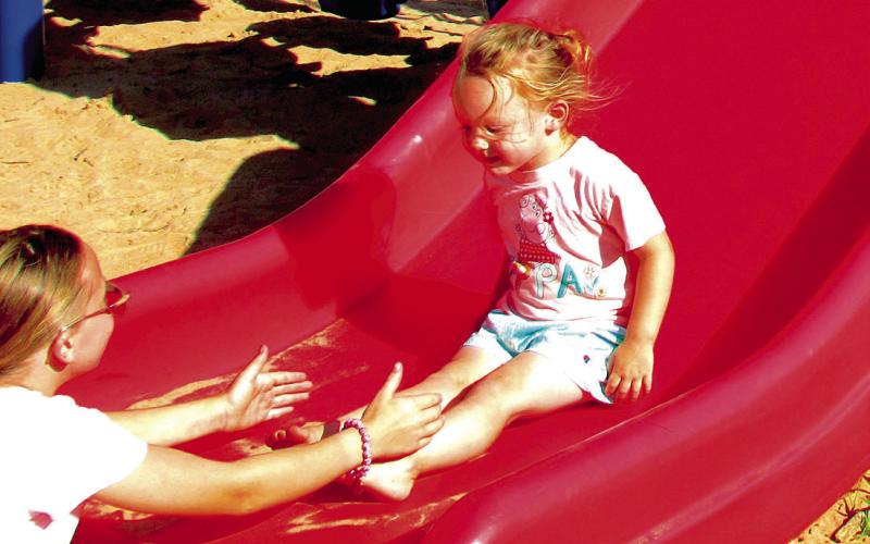 Sophie Hoover happily slides into the arms of her sister, Dusti Hoover. The two played alongside their brother Luke Bush at Memorial Park while the sun shined bright.