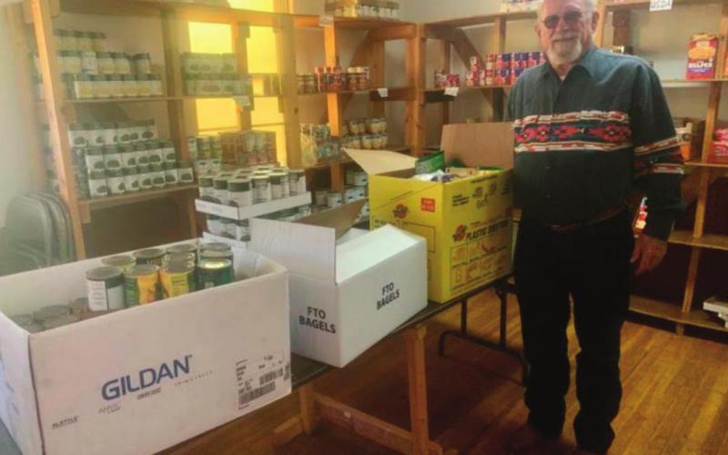 Ted Wilson of Drumright stands in front of shelves fi lled with donated canned goods at the Drumright Food Pantry.