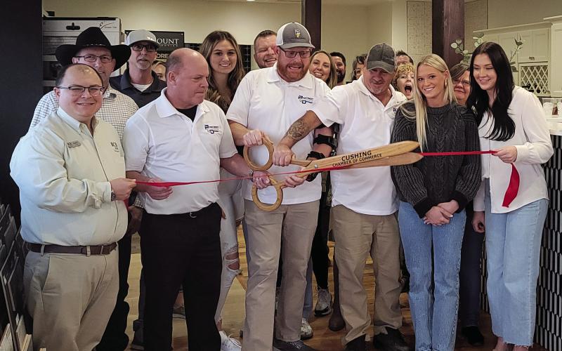 Members of the Cushing Chamber of Commerce surround the owner of Precision Flooring at the ribbon cutting held Friday, Nov. 17.