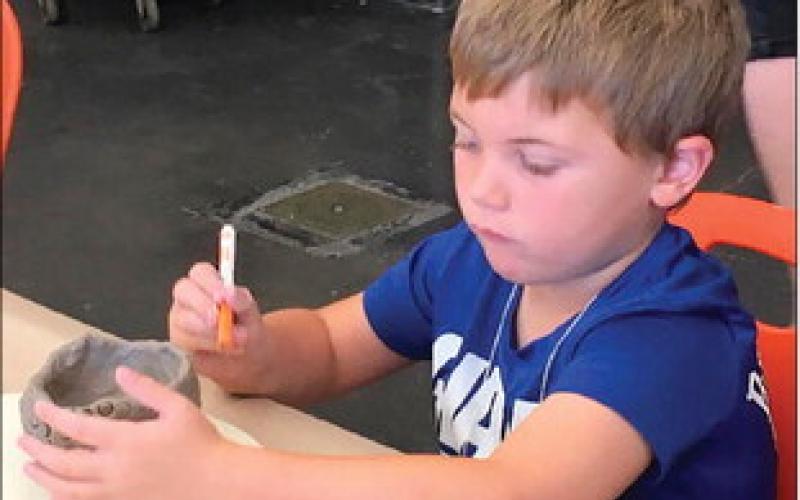 Cushing Art Camp participant Lincoln Bray focuses on putting the finishing touches on a sculpted project