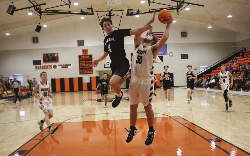 Agra Bearcat Brogan Howard goes to put up two in the paint while Meeker Bulldog Devin Silgar tries to intercept during the Bearcats game against the Dawgs during the Agra invitation tournament Friday, Dec. 9. Bearcats lost to meeker 72-77 in overtime. Photos by Allie Prater