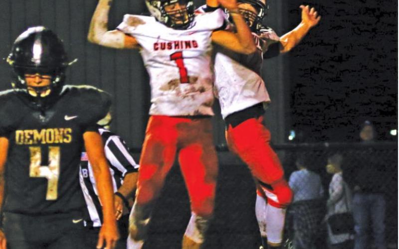 Blaze Berlowitz and Austin Munday celebrate a TD pass during the Tigers 27-7 victory over country rival Perkins-Tryon Friday. Berlowitz threw for 340 yards.