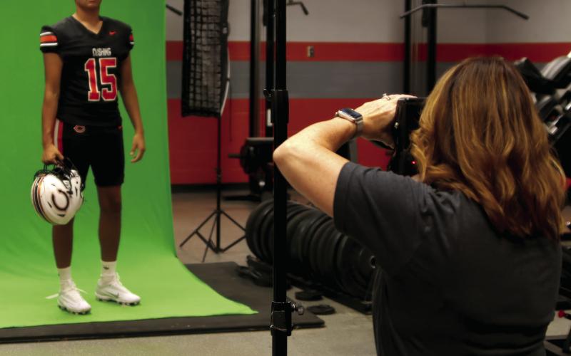 Brandy Moton, of Moton Photography, gets a set of photos of Cushing Senior Kamarion Franklin inside the Tiger weight room during Cushing’s Media Day on Saturday. Photo by J.D. Meisner