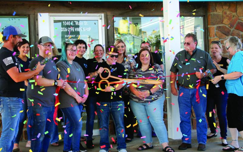 Surrounded by friends and fellow Cushing Chamber of Commerce members, Tera Schooley, owner of Dig Lyfe Vapor Co., wields the scissors at the ribbon cutting and grand re-openeing celebrating Dig Lyfe Vapor's new location at 1046 E Main Street, Thursday, July 18. Photo by Allie Prater.