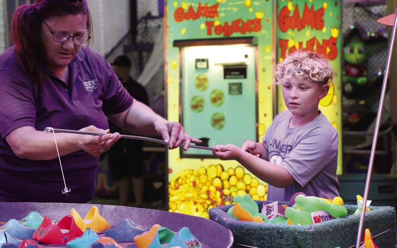 Haskel Travis, of Perkins, concentrates as he tries to hook a fish at a carnival game during the Payne County Free Fair. Photo by Allie Prater