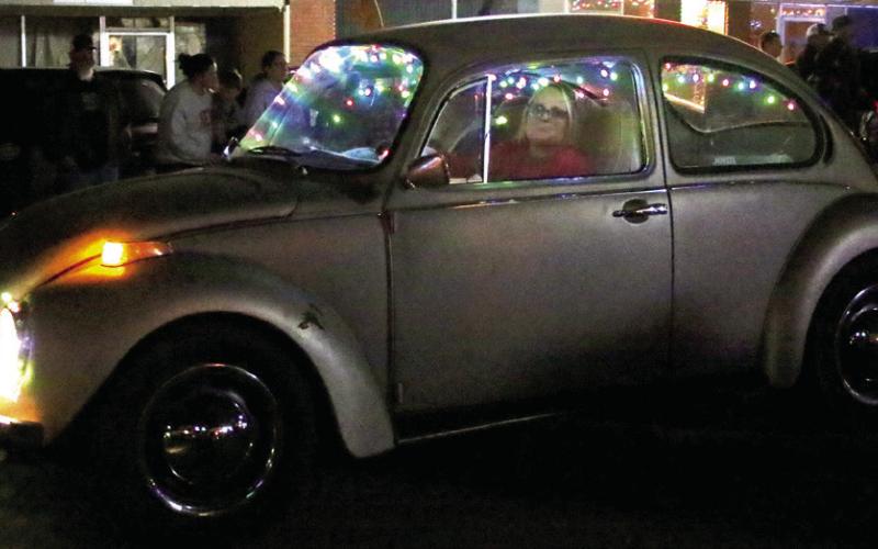 Lori Jones drives Rudolph the Red Nose Slug Bug, a 1974 VW Super Beetle owned by John Studebaker, down Broadway.