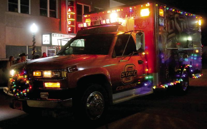 Rotary Club of Cushing spreads Christmas (and Cowboy) cheer from their OSU themed ambulance driven by Mike Gaskins