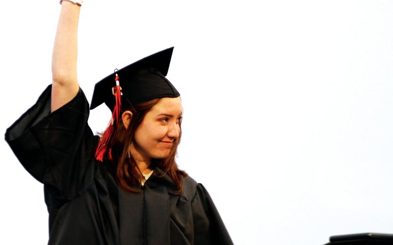 Kirsten Kitchen-Hill holds her diploma high as she crosses the stage at Friday’s Cushing High School graduation ceremony.