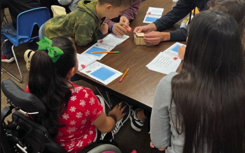 Kale Robinson, Korben Gaskins, and Emilee Parson demonstrate the importance building materials makes as they help second grade Cushing Upper Elementary students construct a house of sticks for three little pigs during an interactive STEM project.