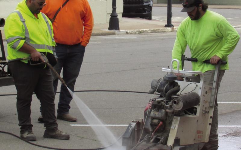 City workers Sean McDowell, Billy Hickman, and Ricky Johnson cut through the asphalt of Harrison Avenue just passed Broadway Street on April 24 in preparation for a new waterline installation. Photo by DeAnna Maddox