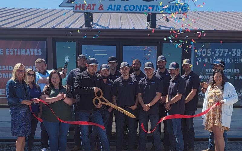 Air-O Owner Chris Vasquez cuts the sash during the ribbon cutting ceremony for the business held on April 11. Cushing Chamber of Commerce officials, local business owners, and employees stand together to celebrate the event.