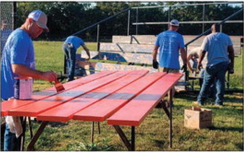 Enbridge employees painting bleachers at Yale Elementary School.