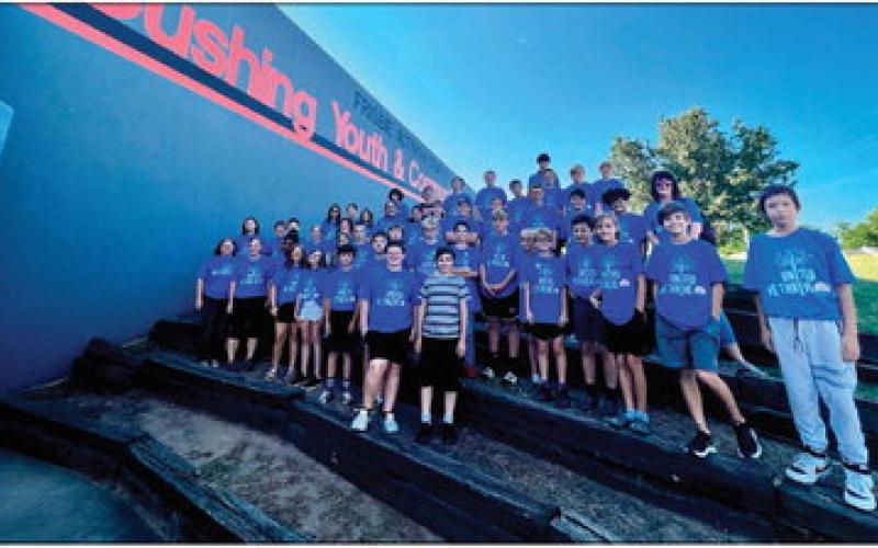 Students from Oak Grove Public Schools gather in front of the Cushing Youth Center cleaning and disinfecting.