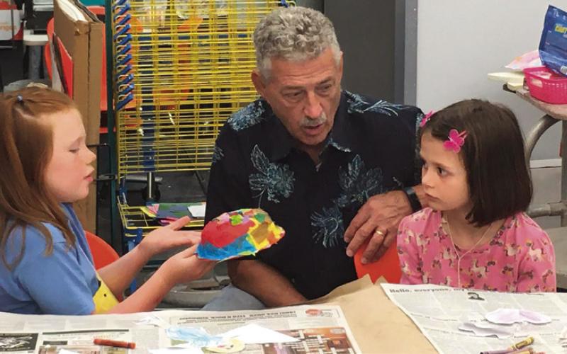 Representative John Talley discusses how to make a mask with Hadley Marshall (left) and Piper Sigle during the last week of the most recent Cushing Art Camp held at the Cushing Middle School.