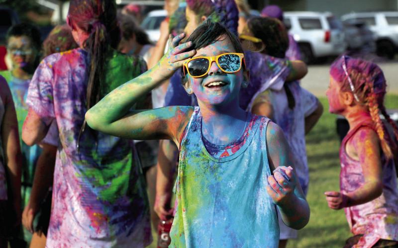 Julz O’Kelley brushes the hair off her prismatic face after the “color explosion” at the 2024 Do or Dye color run hosted by the Geographic Club of Cushing Saturday, Aug. 17. Photo by Allie Prater. See page 6 for more color run photos.