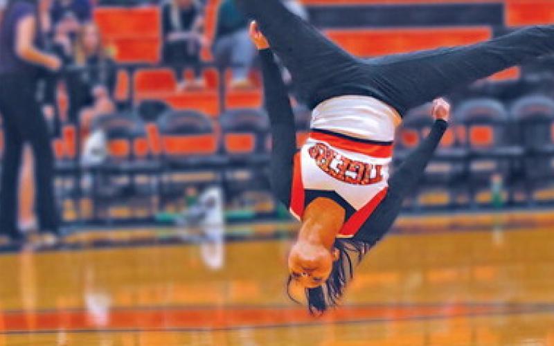 Lindy Candler performs a tumbling pass during the Tiger Dance Team’s performance at halftime of the boys game against Mannford. See story inside. Photo by J.D. Meisner.