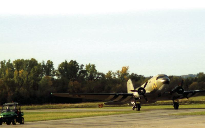 Airport Manager Mike Middleton leads a C-47 to to the tarmac at the Cushing Municipal Airport during the Fly-in and Fun Fair held last fall. Photo by J. D. Meisner