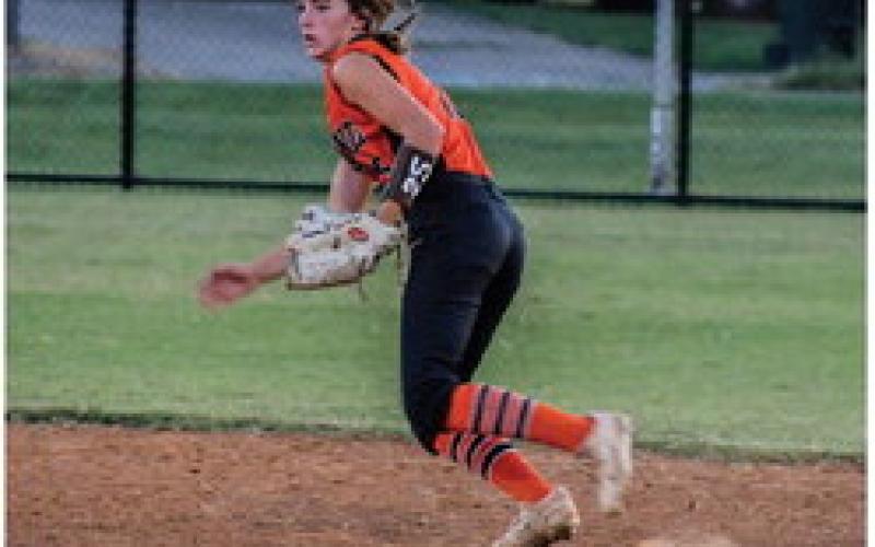 Kinsley Williams readies herself at bat. Laramie McCoy runs to catch a grounder.