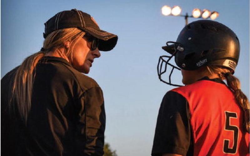 Cushing Softball Coach Nikki York talks with Alyssa Roe at third base.