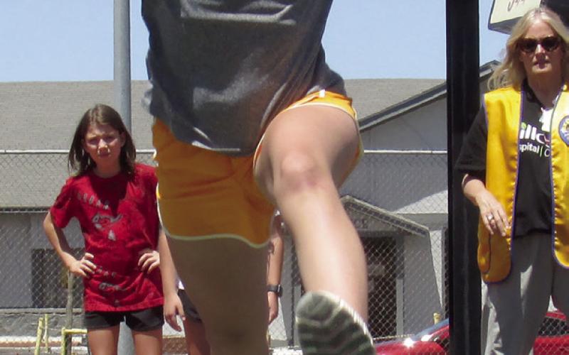 Violet Zwanziger attempts to go the distance in the Long Jump for 5th grade girls during the annual Cushing Middle School Junior Olympics organized by Cushing Lion’s Club members with additional volunteers from area businesses.