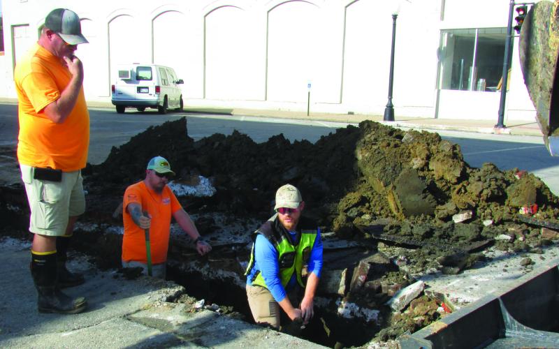 City crew members Daniel Burt and Justin Mosher dig in the dirt to replace a waterline on South Harrison Avenue from Cherry Street to Broadway while Billy Hickman supervises and Steven James works construction equipment to clear away debris last Wednesday on Sept. 4. Burt said there would be further work due to future street and sidewalk renewals that are planned. Photo by DeAnna Maddox