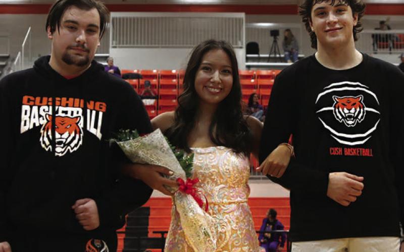 Homecoming royalty candidates Grayson Treanor, Morgan Franklin, and Tagun Fittje pose for the camera during the coronation ceremony.