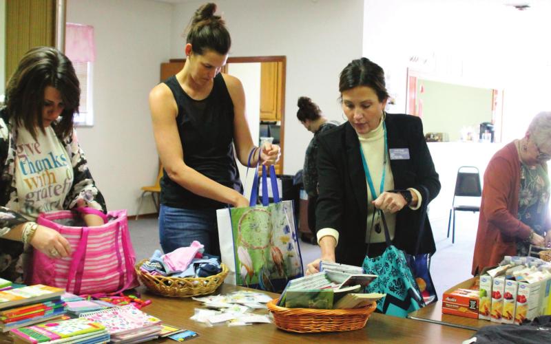 Kinetic Church TRIBE members help fi ll care totes with items purchased from donations of partnering churches. Pictured from left are Whitni Greer, Alycia Finkbeiner, Candi Bugg and Penny Cohenour.