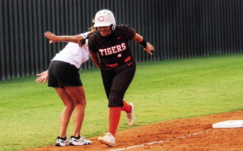Ava Hepensberger gets a little love from head coach Nikki York as she rounds third after crushing a homer over the left field fence. Photo by Dallas Lauderdale