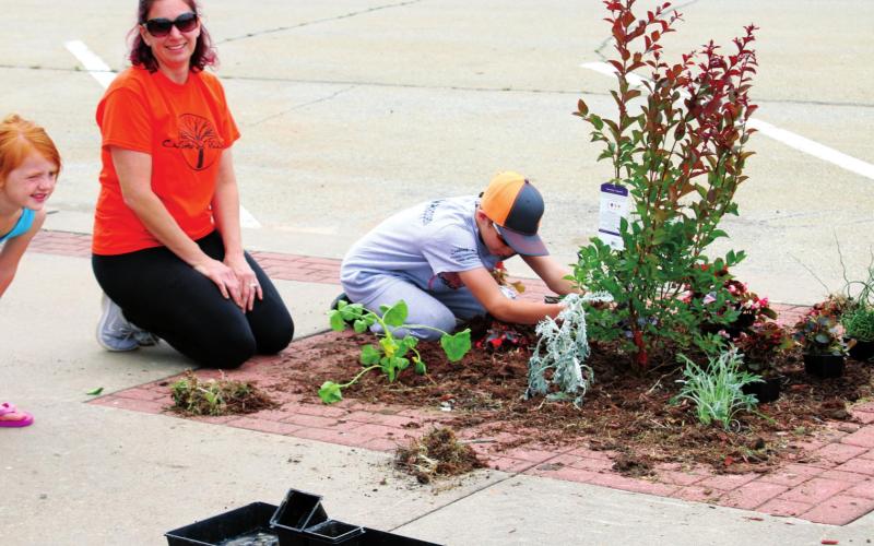 Bailey, Shawna and Caleb Swindell work to beautify their part of Broadway Saturday, during Cushing Pride’s May on Broadway event.